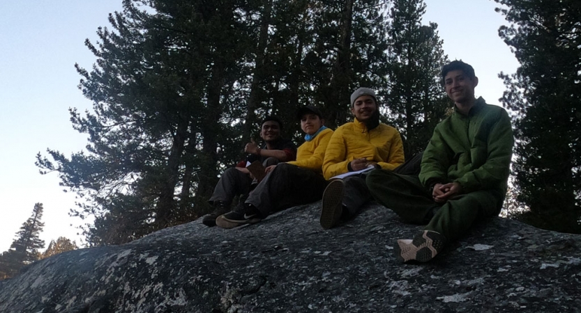 a group of students rest on a rock during an outward bound backpacking expedition for bipoc